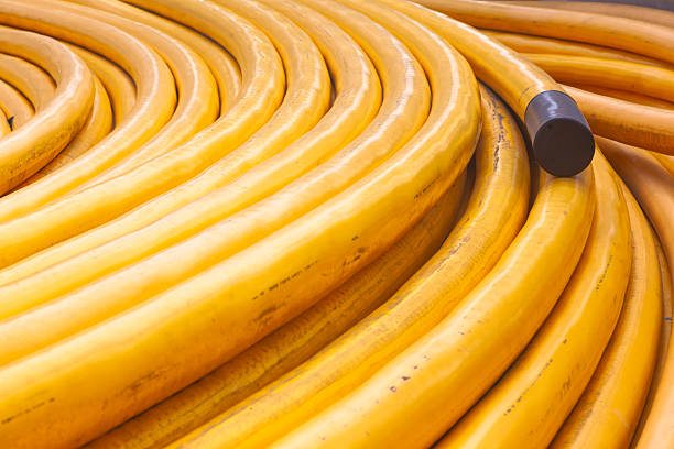 New powerful high-voltage cable in yellow braiding twisted on the ground.