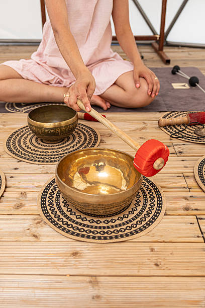 istock Woman using a singing bowl during a sound therapy session 2220973180