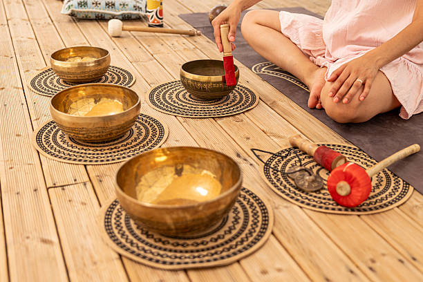 istock Woman using a singing bowl during a sound therapy session 2220973243