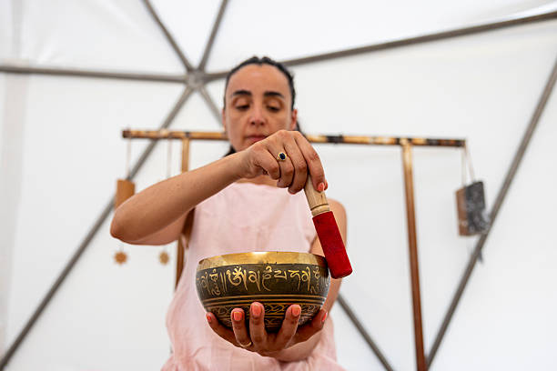 istock Woman using a singing bowl during a sound therapy session 2220973247