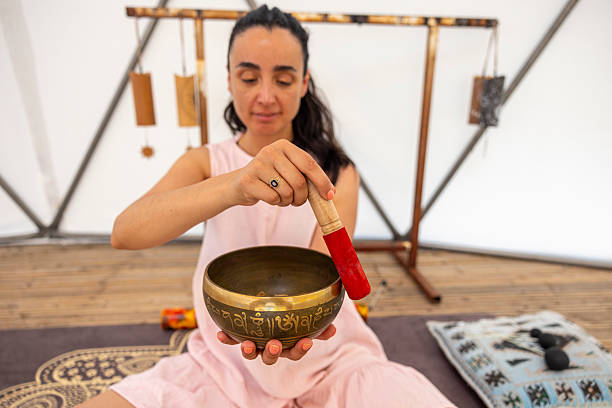 istock Woman using a singing bowl during a sound therapy session 2220973300