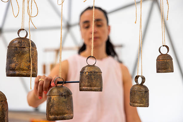 Meditating woman playing healing bells during a spiritual session