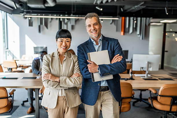 istock Two smiling business people standing in modern office 2220975089