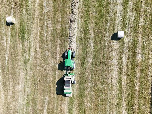 istock A tractor with a baler in the field, shot with a drone 2220975335