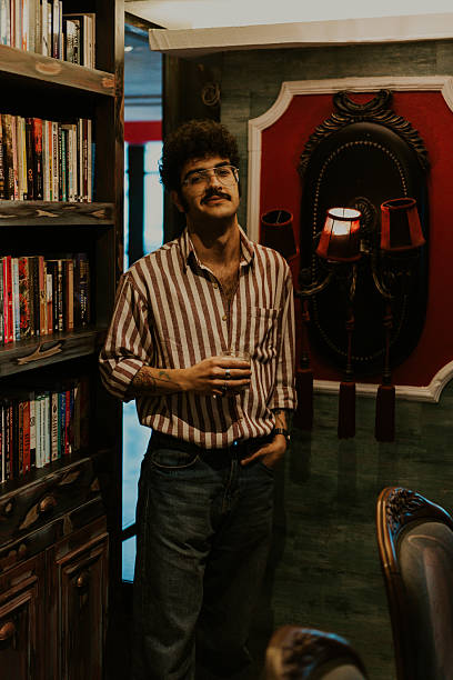Young man drinking in a luxurious home library