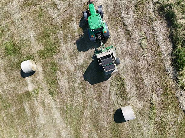 istock A tractor with a baler in the field, shot with a drone 2220976011