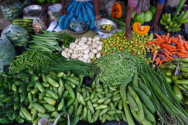 istock Shopkeepers are displayed several vegitables in the market settings like cucumber, garlic, lemon, pumpkin and many others 2220977302