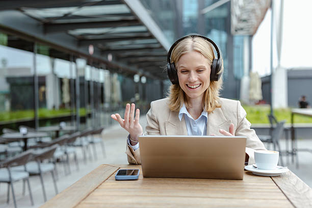 istock Businesswoman on a video call outdoors using a laptop and headphones 2220978024