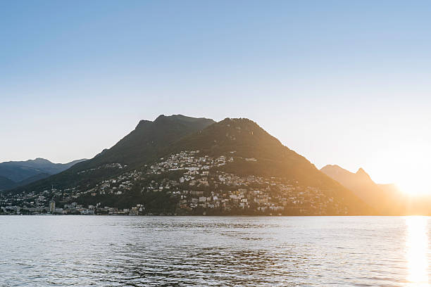 istock Sunrise over lake, mountains and village 2220980554