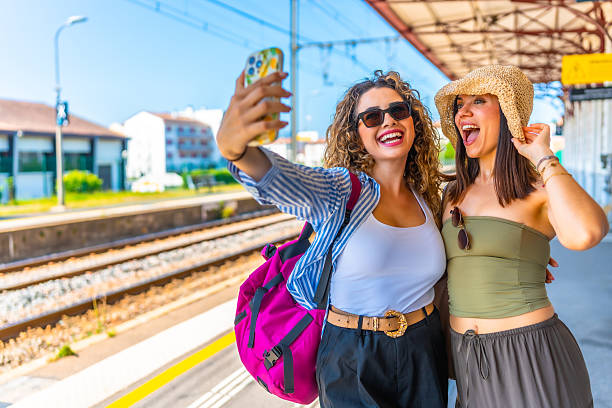 istock Two happy tourists taking selfie at train station 2220981997