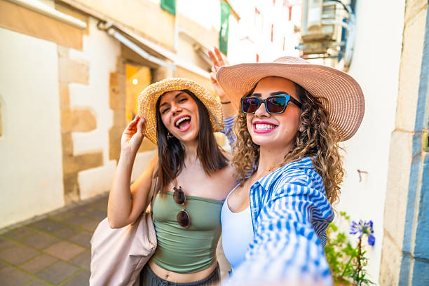 istock Two happy tourists taking a selfie while walking down a narrow street 2220982022
