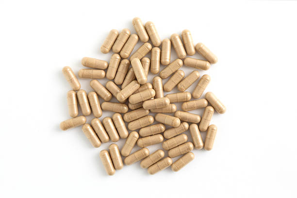 istock Brown herbal capsules top view isolated on white 2220982365