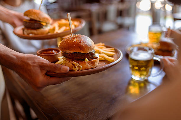 Delicious burger and fries in cozy restaurant interior - perfect for fast casual dining promotions, bar food marketing, or social media food content.