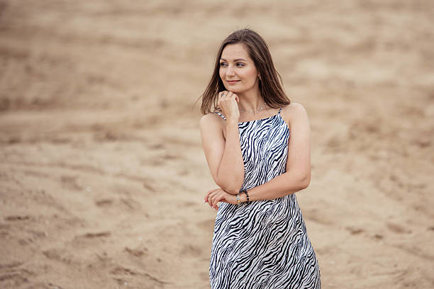 istock Charming young woman on sandy desert background, looking away, copy space 2220987033