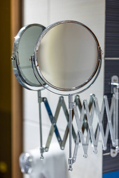istock Round bathroom magnifying mirror mounted to the wall with a pantograph. 2220993291