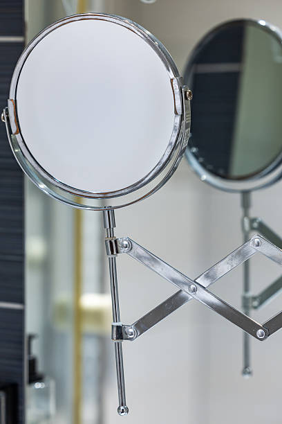 istock Round bathroom magnifying mirror mounted to the wall with a pantograph. 2220993314