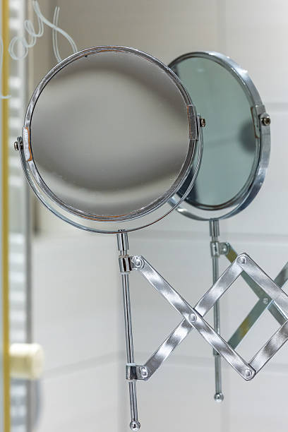 istock Round bathroom magnifying mirror mounted to the wall with a pantograph. 2220993353