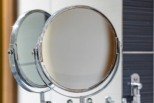 istock Round bathroom magnifying mirror mounted to the wall with a pantograph. 2220993376