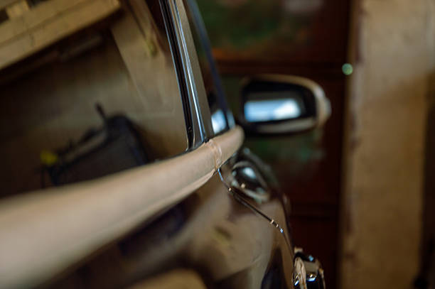 istock A car receiving polishing attention inside a garage, highlighting gleaming surfaces and reflections in the dim light 2220996902