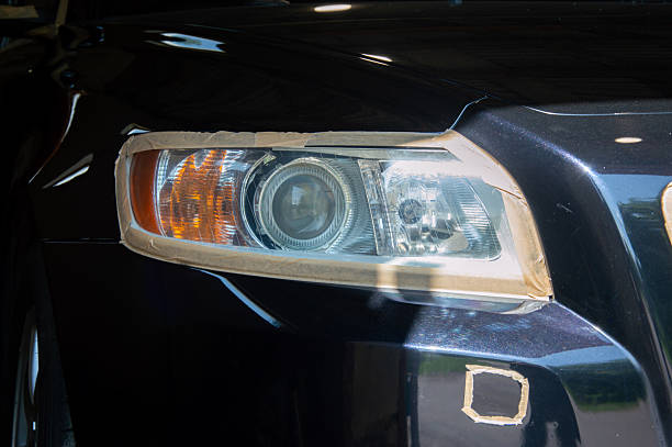 istock An expert performing car polishing, using masking tape to shield headlight and surrounding areas for precision 2220996909