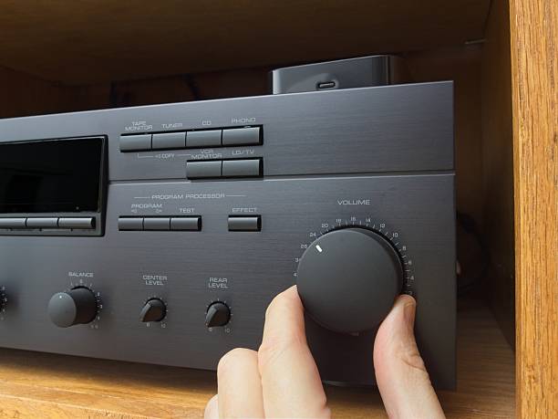 istock Turning up the volume knob on vintage stereo amplifier 2221001269