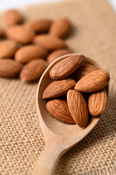 istock Raw almond nut seed in wooden spoon 2221003519