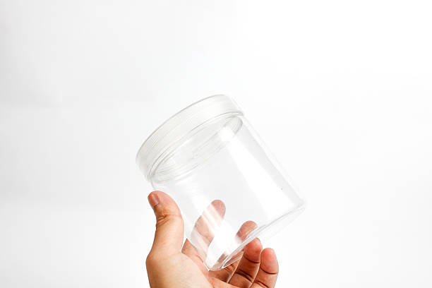 istock man's hand holding small transparent plastic jar isolated on white background 2221003657
