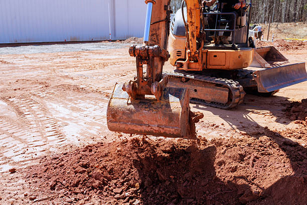 istock Excavator moves dirt at a construction site during daylight in a forested area 2221009685