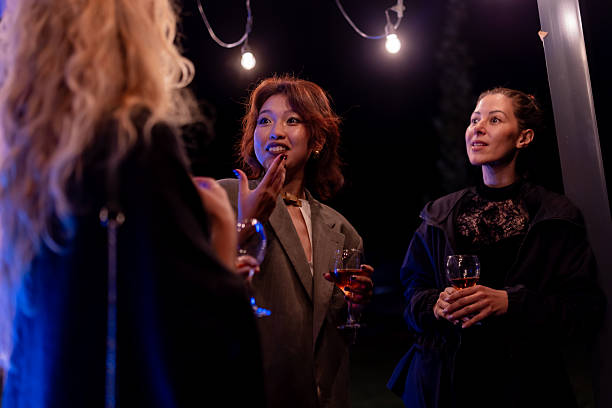 istock Three women enjoying an evening conversation outdoors at a gathering 2221011769