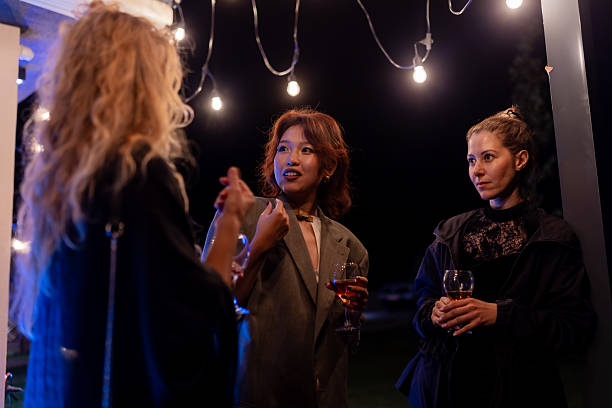 istock Group of friends enjoying a social gathering at night outdoors under festive string lighting 2221011773