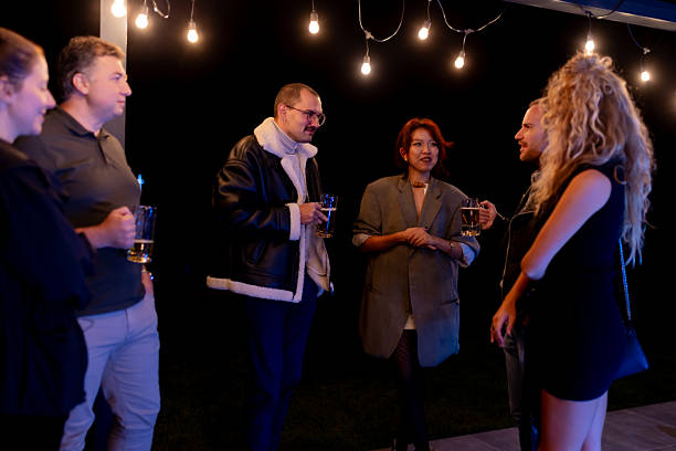 istock Group of friends socializing outdoors under string lights at nighttime 2221011795