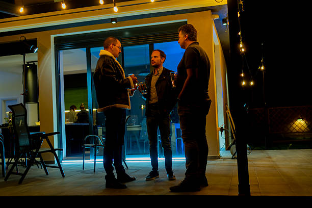 istock Friends talking and socializing outdoors at night under ambient string lights 2221011813