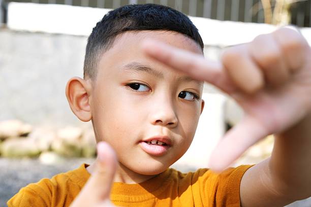 Baby boy hand finger pointing to colorful 123 numbers on light blue table background. Pastel color. Time to learning. Closeup. Top down view.
