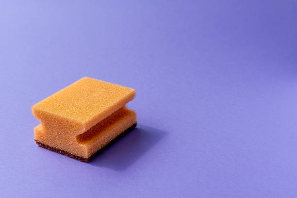 istock one yellow sponge on the violet background. 2221012291