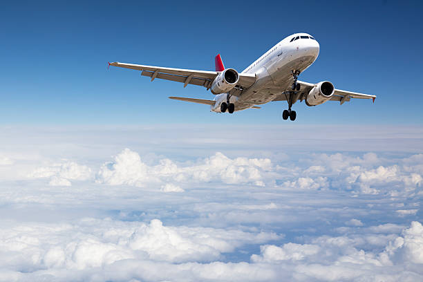Passenger jet airplane flying above clouds