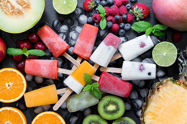 Delightful summer berry ice cream pops arranged beautifully among fresh fruits and ice