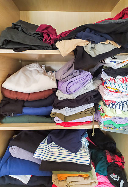 istock Overstuffed closet with piles of colorful clothes, showcasing disorganization and clutter. Represents lifestyle, storage challenges, or the need for decluttering. 2221020719