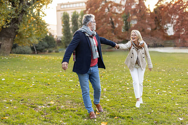istock Couple Walking Hand in Hand Through Autumn Leaves 2221026166