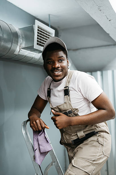 istock Worker smiling while on ladder, preparing for home maintenance in a cozy indoor space during daylight hours 2221030549