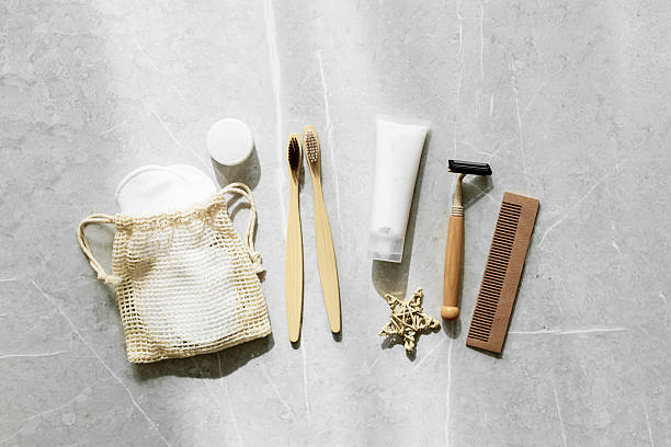istock Sustainable self-care items top view, bamboo toothbrushes, comb, toothpaste in white tube, reusable pads, safety razor on grey marble background. Natural organic Travel cosmetic products set, flatlay 2221030941