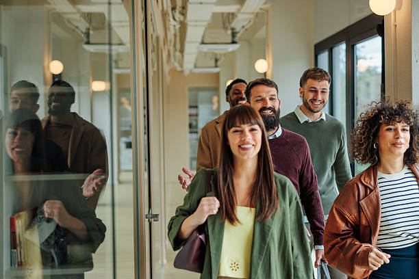 istock Group of happy young professionals walking in modern office corridor 2221031604