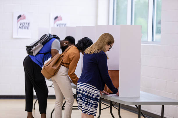 Citizens casting their votes during an election.  Privacy booths ensure confidentiality.