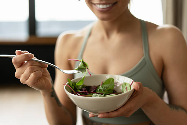 istock Smiling sportswoman eating fresh salad after workout selective focus 2221033915