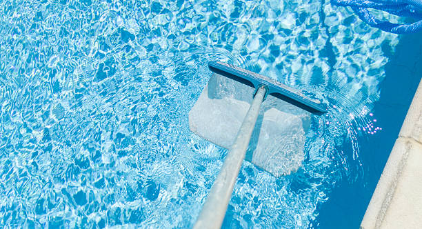 istock Cleaning surface of pool with scoop net 2221034204
