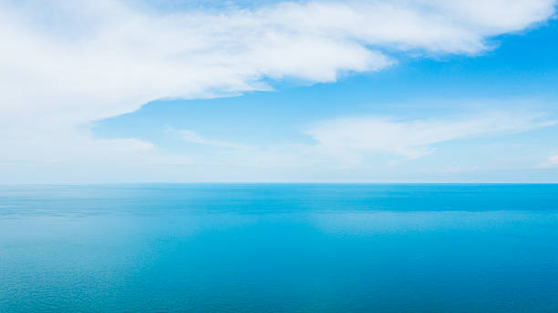 istock Expansive blue ocean meeting a vast sky with soft white clouds, perfect for serene backgrounds. 2221038795