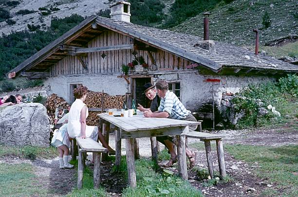 Leutasch, Tyrol, Austria, 1962. Hikers take a break in front of a mountain hut and talk to a mountain guide.