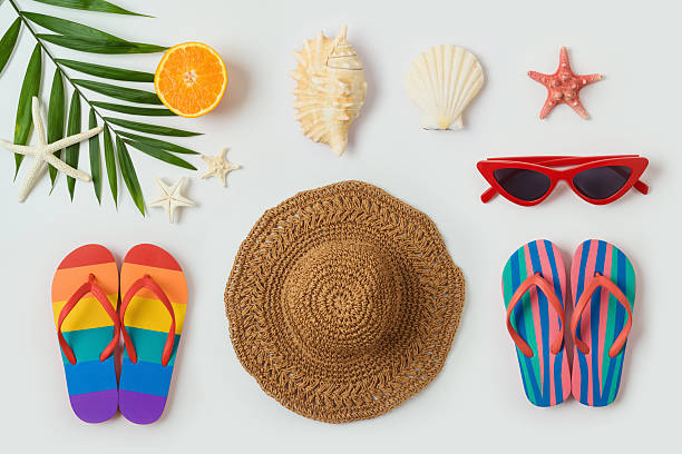 istock Mediterranean summer vacation concept with straw hat, flip flops seashells and palm tree leaf  on white background. Top view, flat lay 2221040072