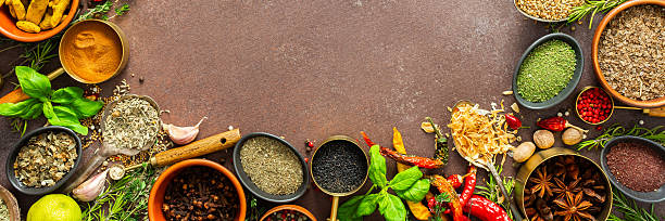 istock A visually striking arrangement of fresh spices and herbs on a brown surface, highlighting their vivid colors, intricate details, and rich culinary essence, banner 2221040336