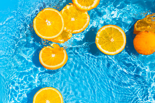 istock Creative summer composition made of sliced orange in transparent pool water with splashes. Refreshment concept. Healthy refreshing drink theme. Top view 2221042782