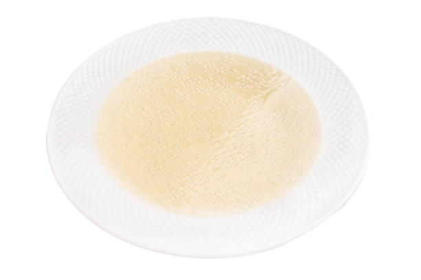 Bowl of chicken broth isolated on white background. top view.